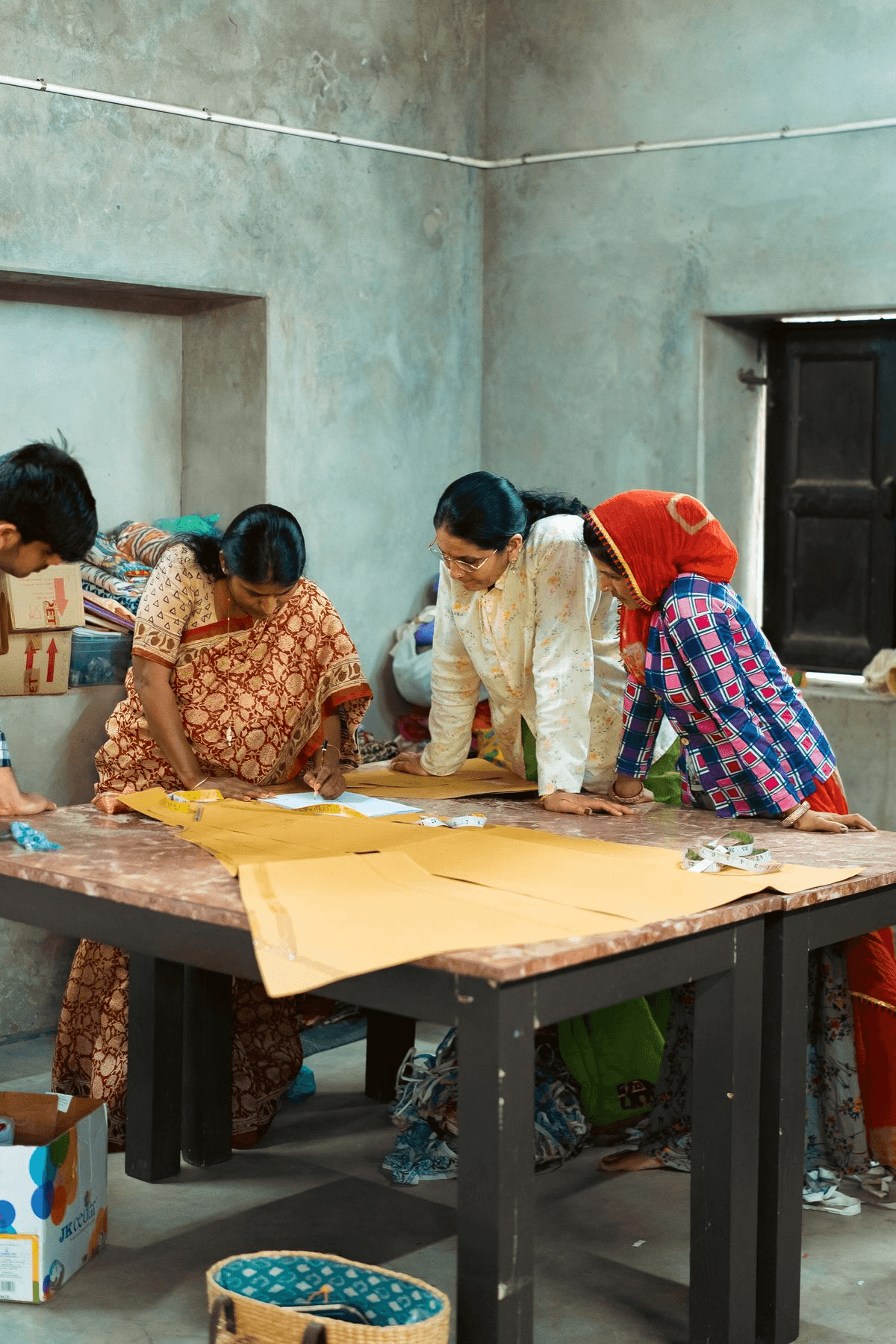 Women artisans drafting garment patterns together